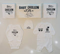 Personalized newborn gift set with custom family name printed on white onesie, sleepsuit, hat, and matching mommy and daddy items